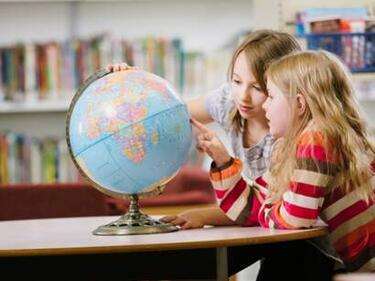 Elementary children looking at a globe