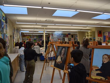 Art displays set up for Art show. Students walking around looking at art pieces