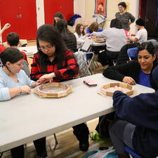 Two female parents support their grade 5 students with their hand drum