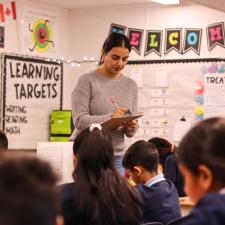 Teacher reading from a clipboard to her class