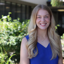 Professional headshot of female employee standing outside.