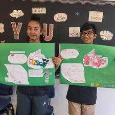 Two middle school students holding poster projects