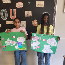 Two female students holding poster projects