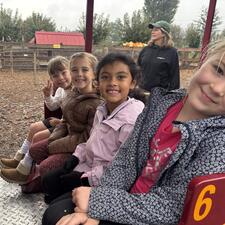 Elementary students sitting on a bench seat on a train at the pumpkin patch waiting to go for a train ride.